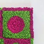 Foto detalle de cerca de cuadro realizado en punch needle. Color verde y buganvilla.
